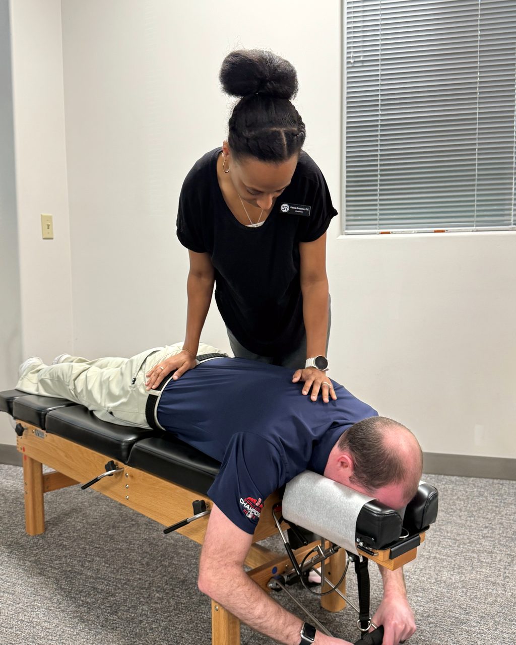 Dr. Kesia Broome assessing a patient's lower back before an adjustment